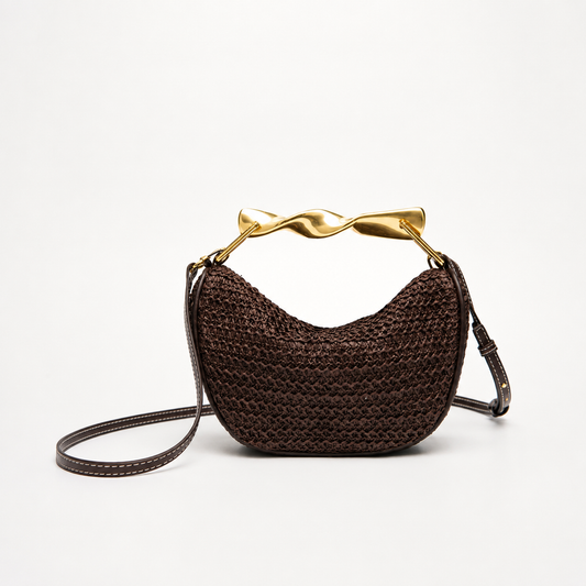 Bolso trenzado Veska con asa metálica, diseño elegante y moderno, mostrado en color neutro con detalles trenzados.
