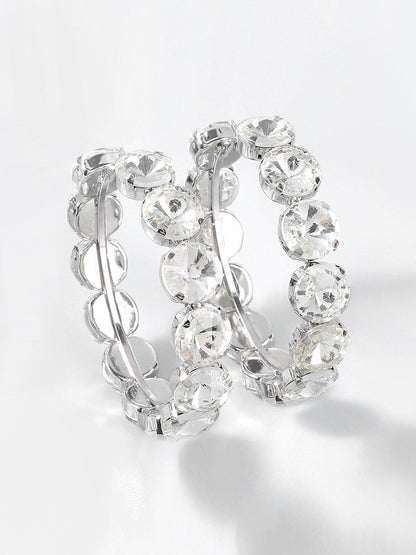 Aretes aro Veska con piedras engastadas, diseño elegante, de tamaño medio y acabado brillante en plata.