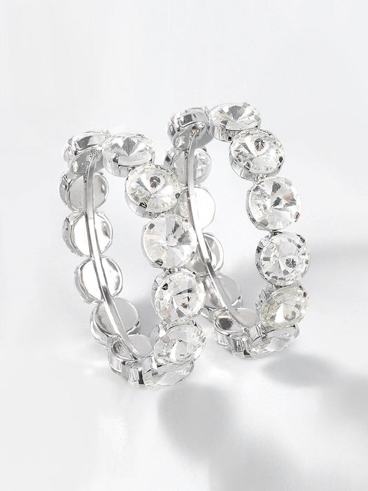 Aretes aro Veska con piedras engastadas, diseño elegante, de tamaño medio y acabado brillante en plata.