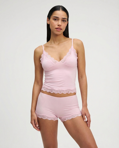 Conjunto Ariana de dos piezas, una propuesta suave y favorecedora diseñada para fusionar el confort absoluto con un toque de elegancia. Este set de loungewear presenta una camisola de encaje con una silueta fluida que se adapta al cuerpo de forma natural, manteniéndose ligera y altamente transpirable en todo momento.