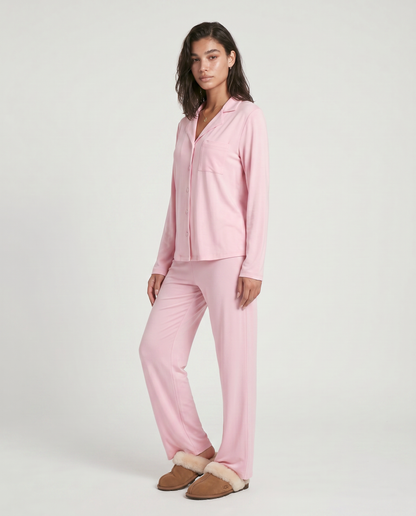 Conjunto Carol de dos piezas, tu nuevo esencial de lujo diario diseñado para ofrecer una experiencia de bienestar absoluto. Este set combina una parte superior de manga larga con botones y pantalones de pierna ancha, confeccionados en una mezcla de fibras suaves con textura
