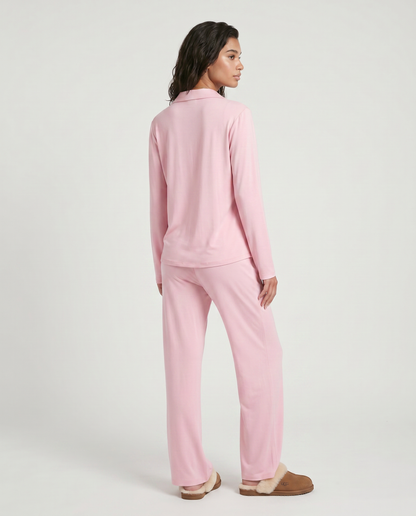 Conjunto Carol de dos piezas, tu nuevo esencial de lujo diario diseñado para ofrecer una experiencia de bienestar absoluto. Este set combina una parte superior de manga larga con botones y pantalones de pierna ancha, confeccionados en una mezcla de fibras suaves con textura