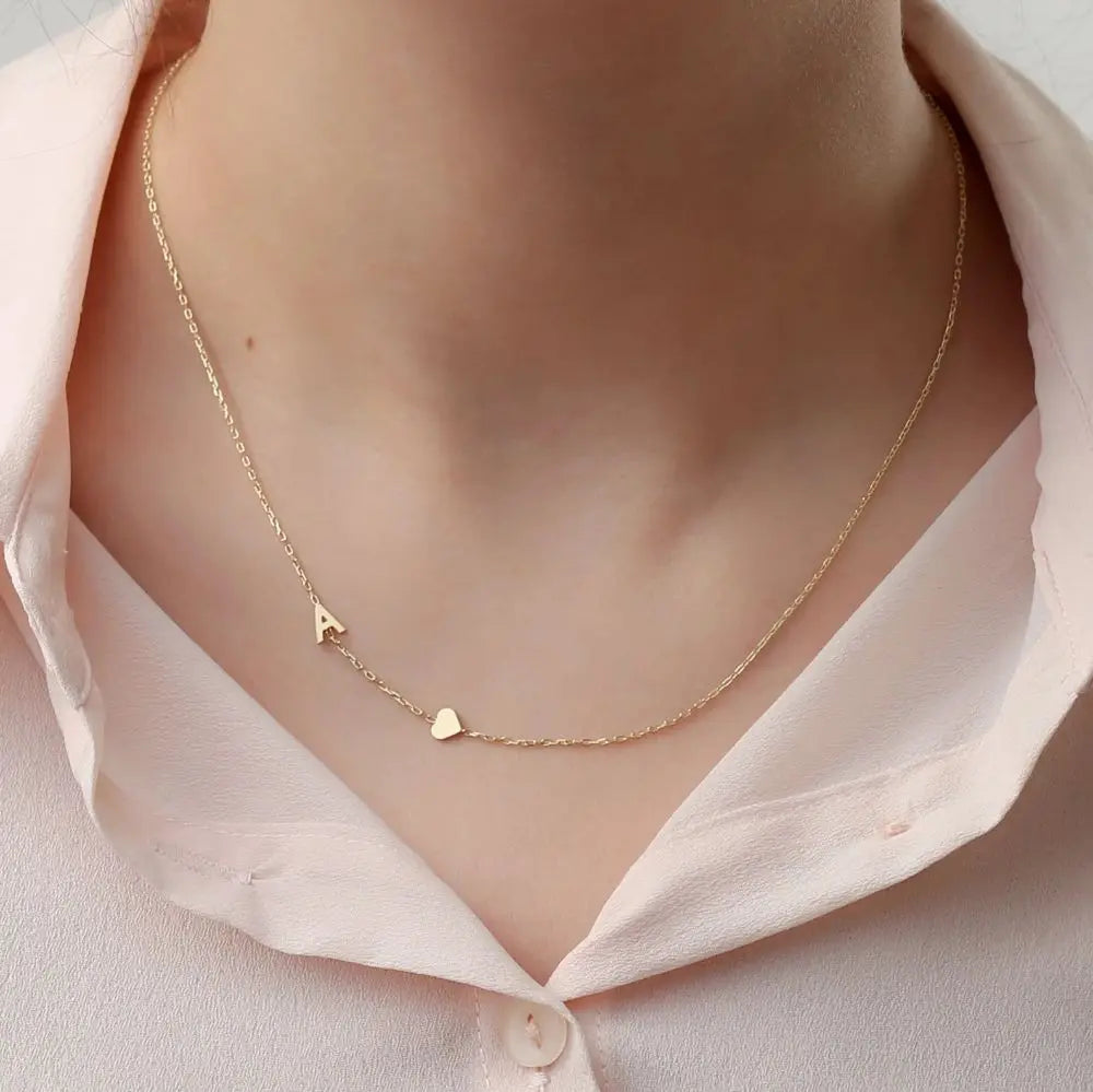 Collar personalizado con iniciales, de la marca Veska, con cadena delicada y letras grabadas en plata.