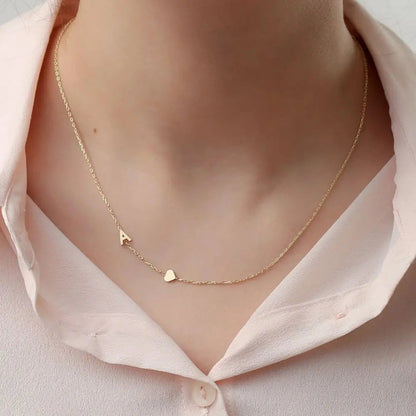 Collar personalizado con iniciales, de la marca Veska, con cadena delicada y letras grabadas en plata.