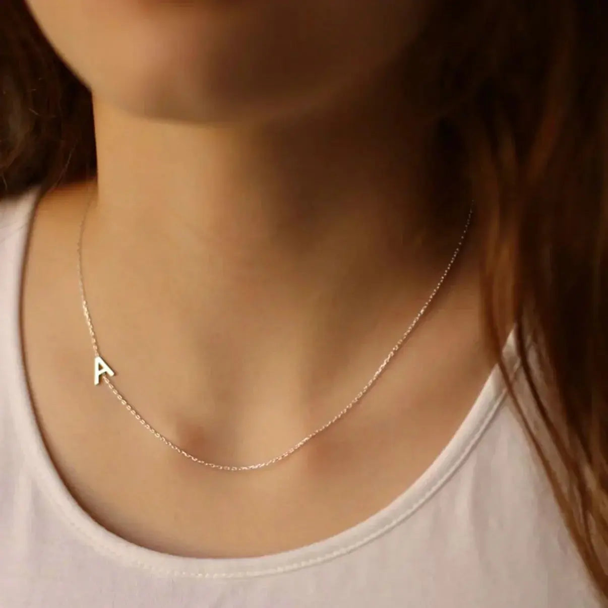 Collar con iniciales personalizadas de Veska, con cadena delicada y letras grabadas, en plata brillante.