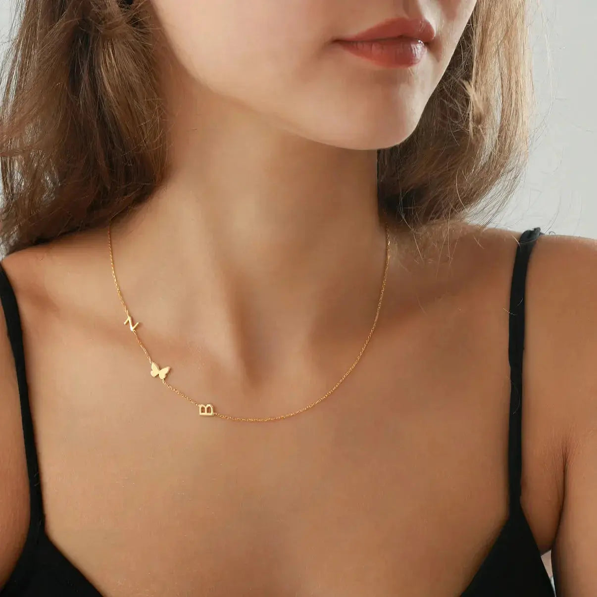 Collar personalizado con iniciales de Veska, con colgante de letras y cadena de plata en imagen.
