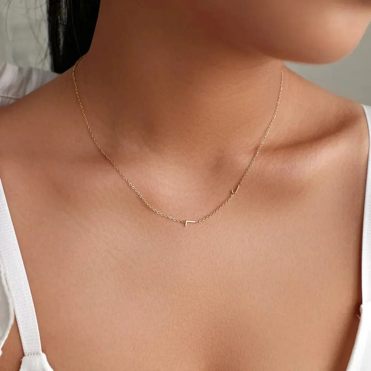 Collar personalizado con iniciales en plata de Veska, con cadena delicada y letras grabadas en el centro.